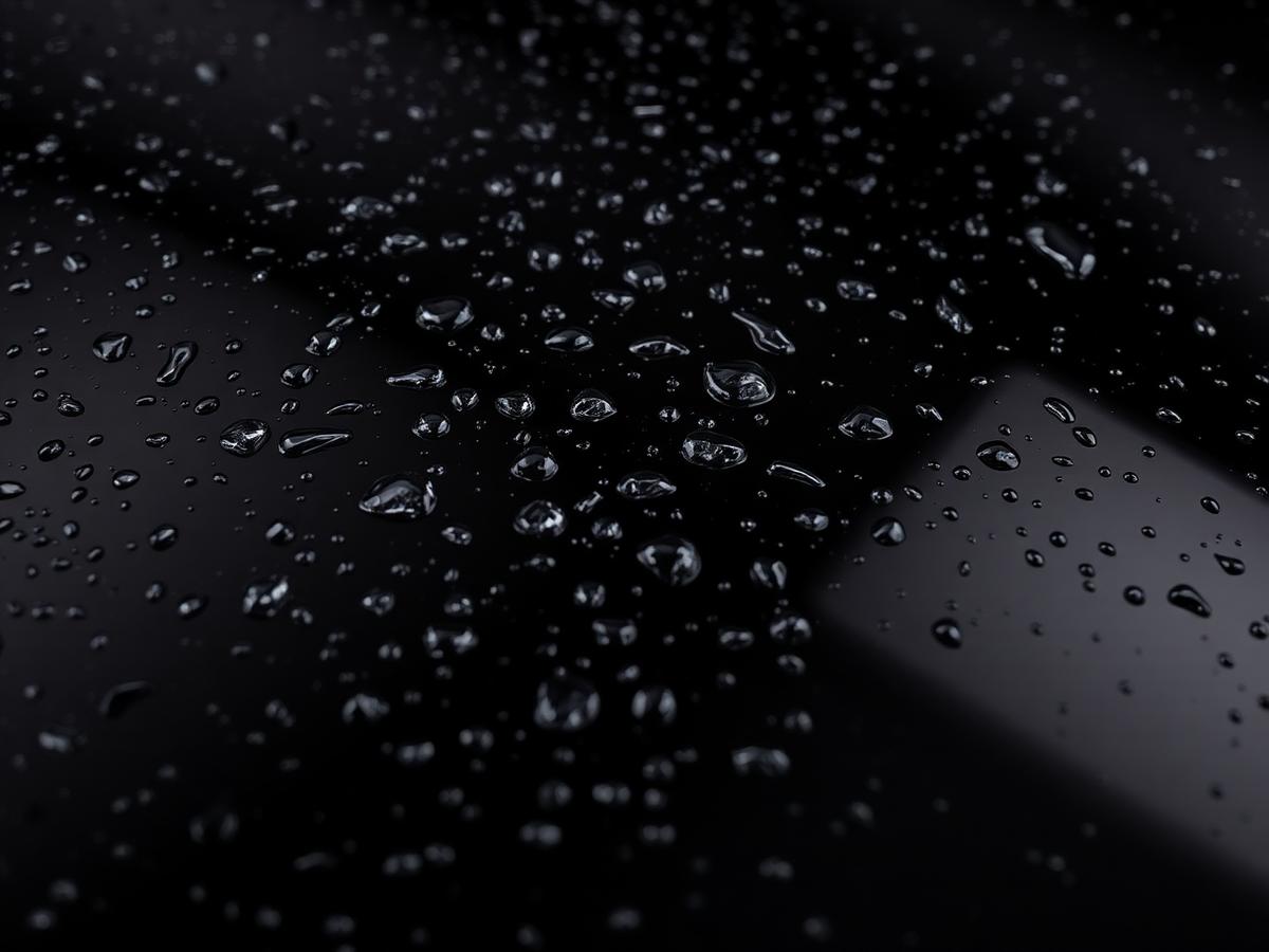 Water beading on a ceramic coated glossy black car hood